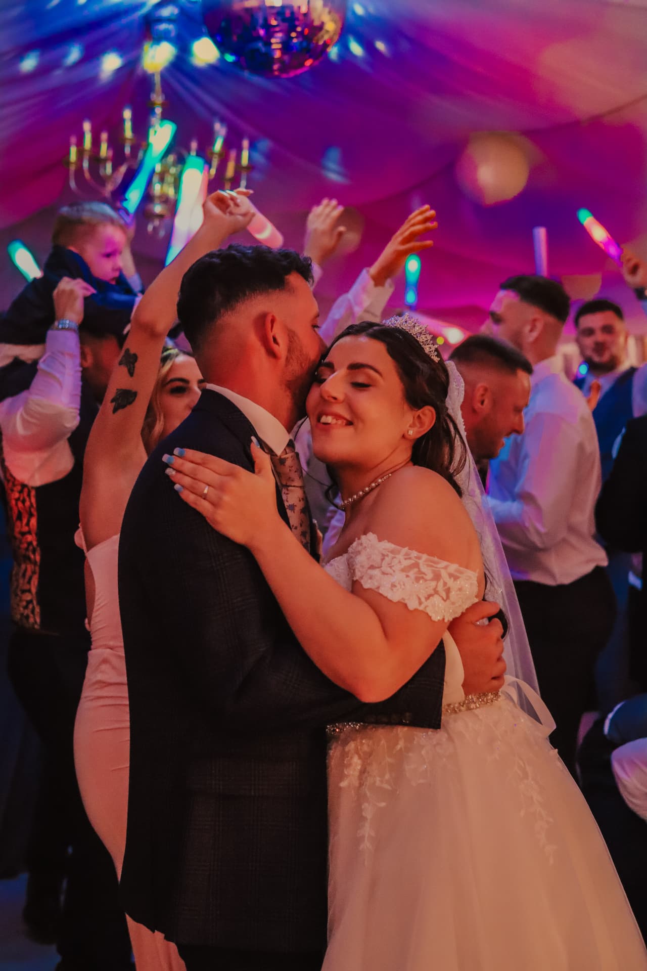 Bride and groom sharing an intimate moment on the dance floor surrounded by celebration lights