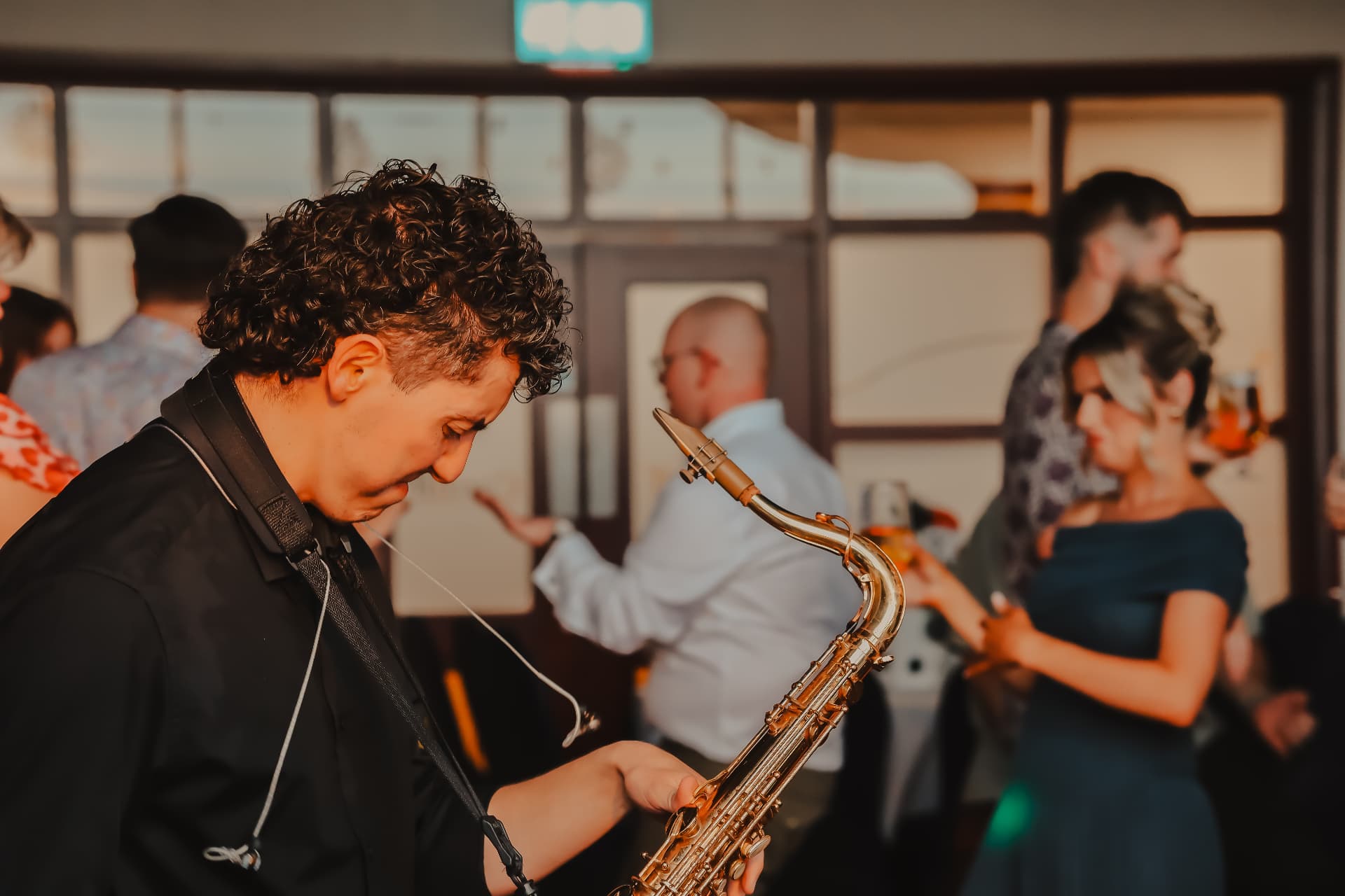 Saxophone musician playing during a warm, atmospheric wedding reception
